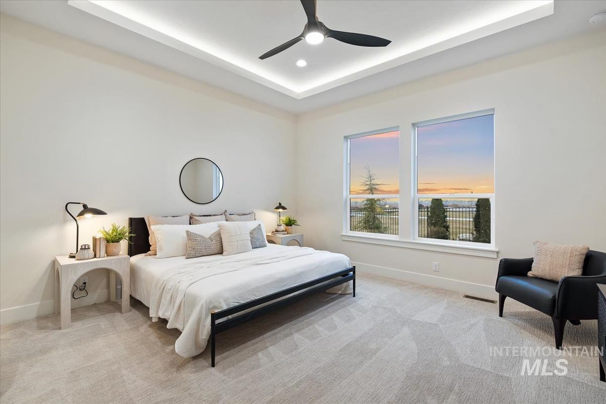 Bedroom featuring a raised ceiling, carpet, ceiling fan, and recessed lighting