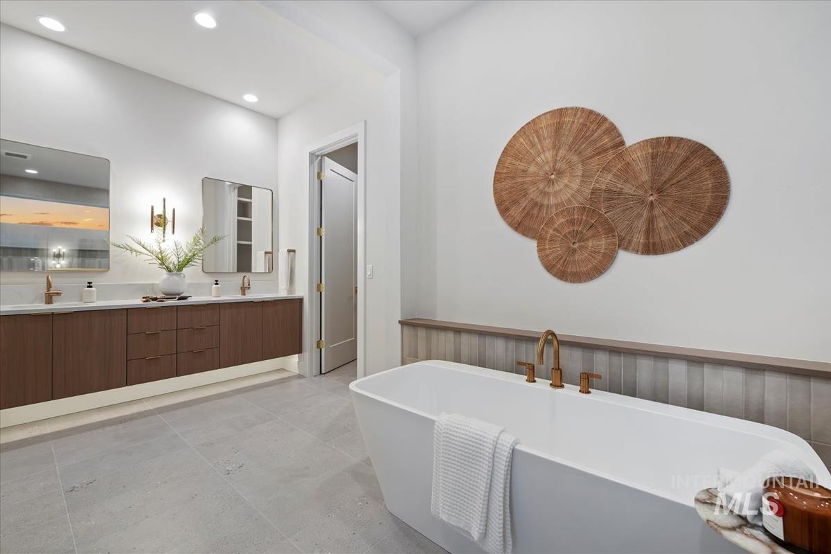 Bathroom with double vanity, a freestanding bath, and recessed lighting