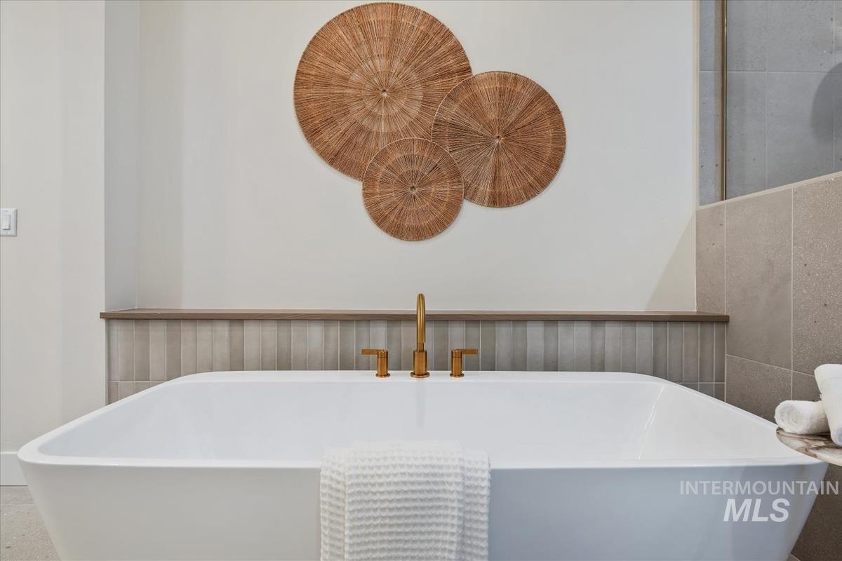 Full bathroom featuring a freestanding bath and wainscoting
