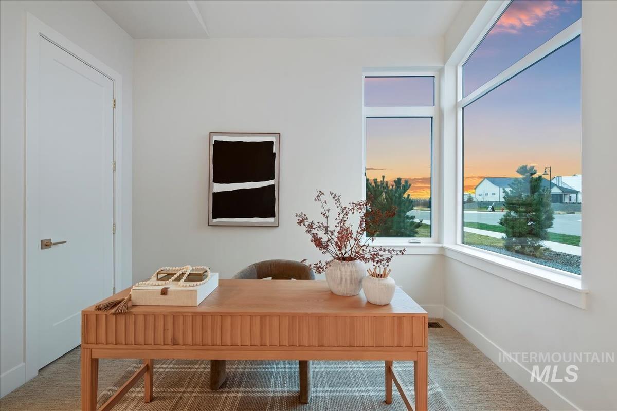 Carpeted home office featuring baseboards