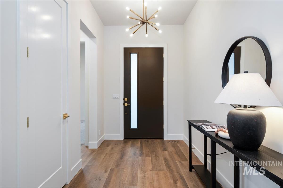 Entryway featuring wood finished floors and a chandelier
