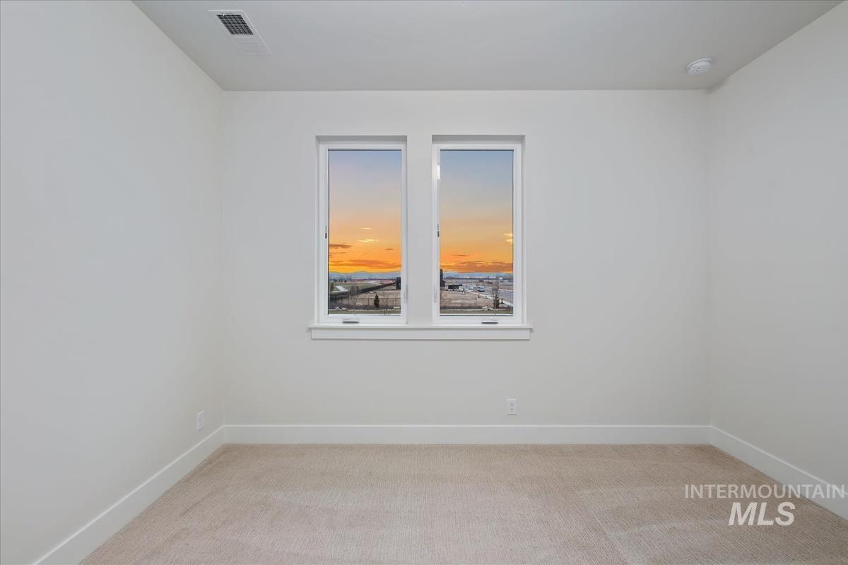 Unfurnished room featuring light colored carpet and baseboards
