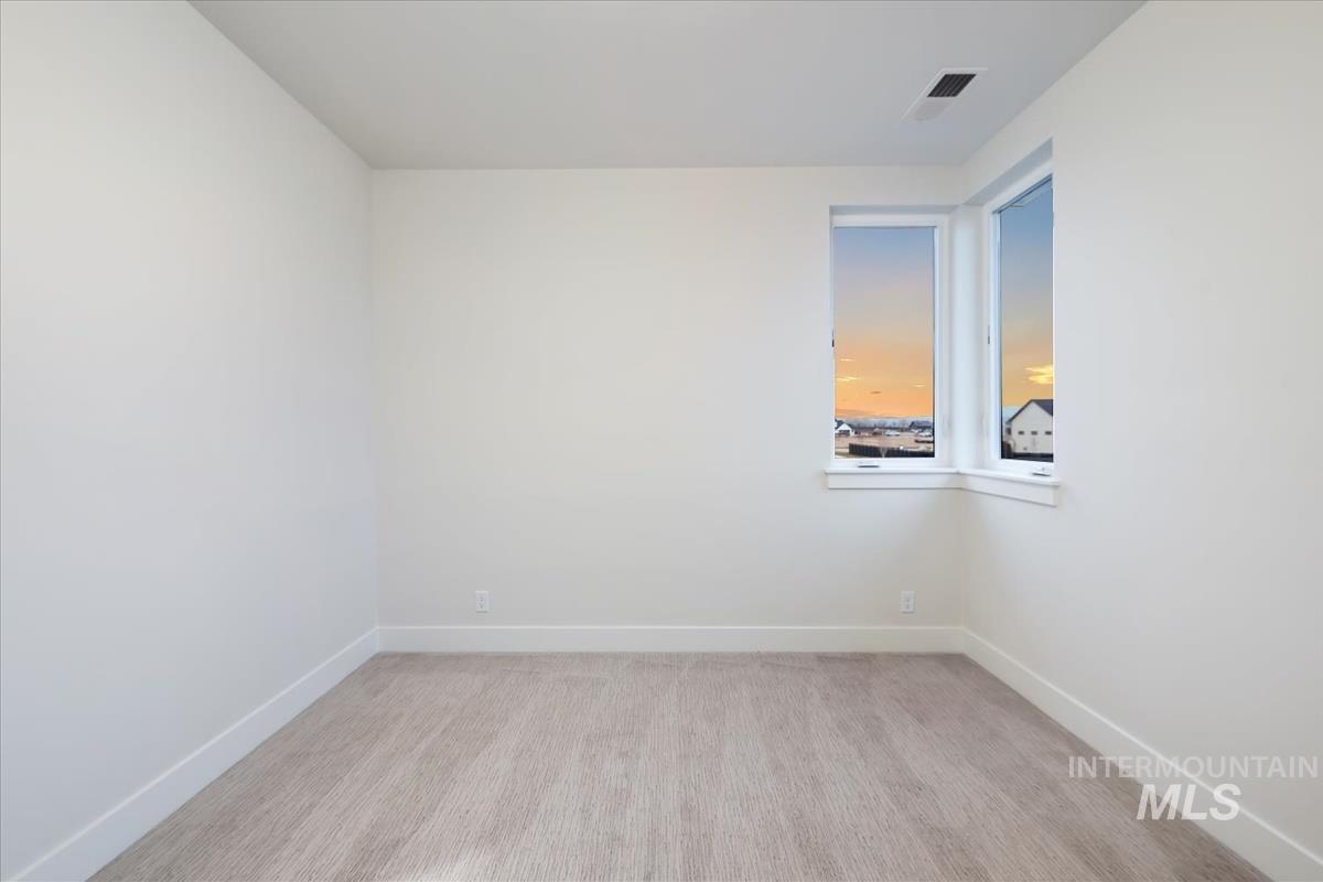 Spare room featuring baseboards and light wood-style flooring