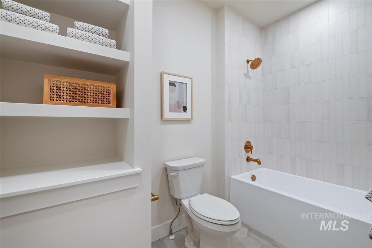 Bathroom featuring washtub / shower combination and toilet