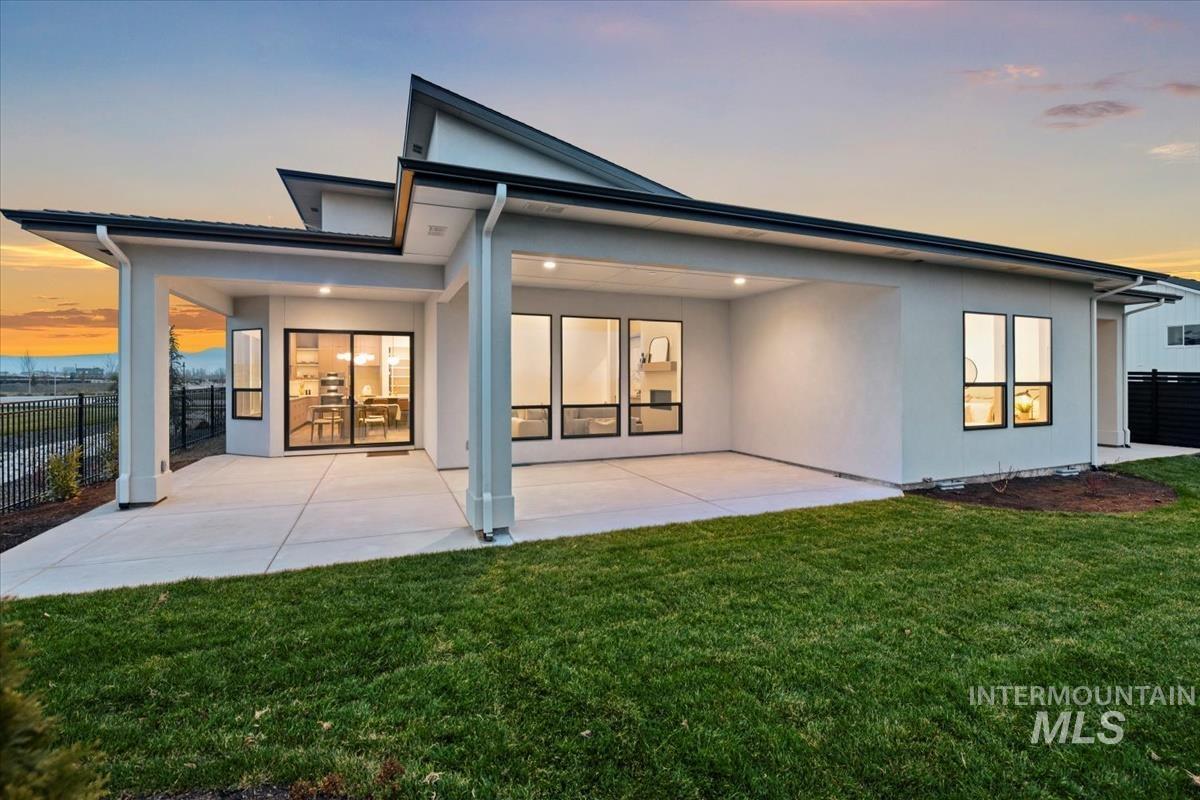 Rear view of house featuring stucco siding and a patio area
