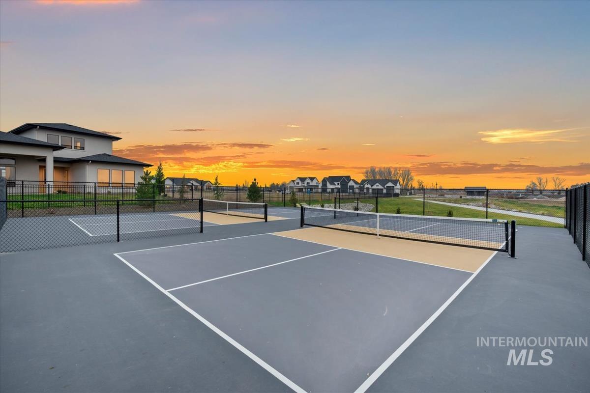 View of tennis court with community basketball court and a residential view