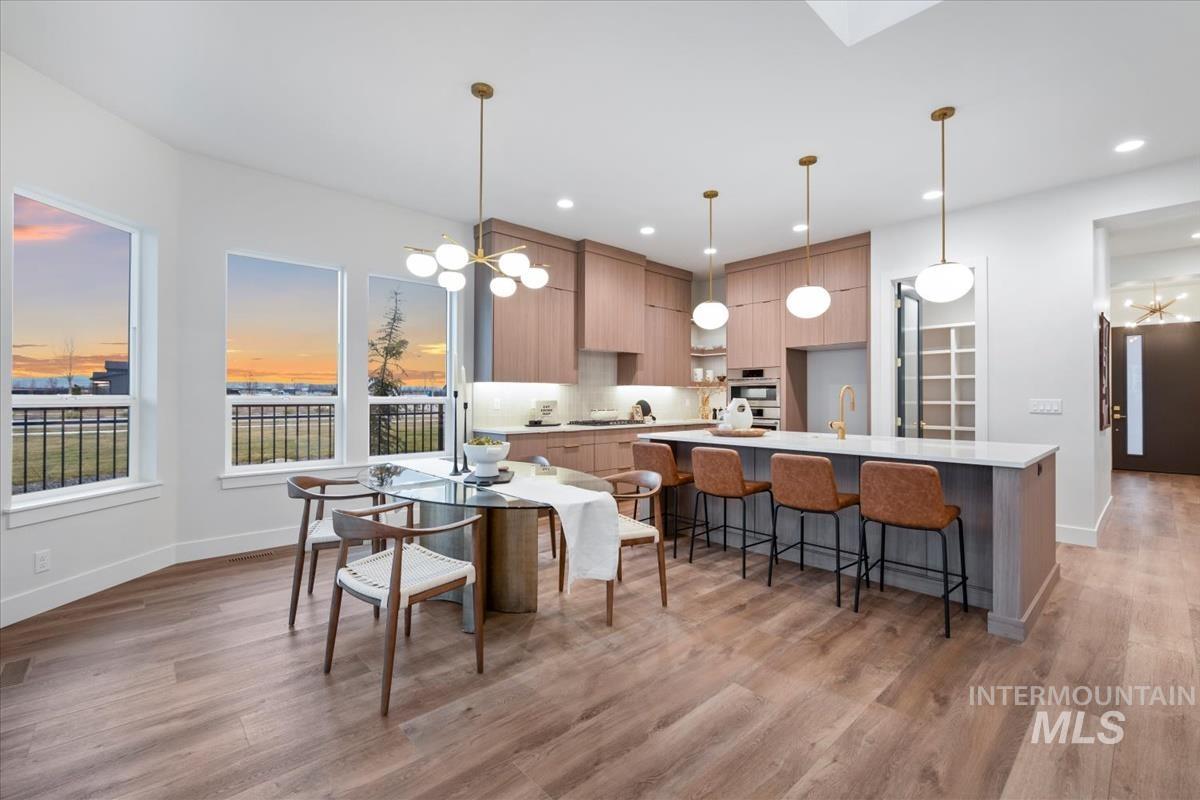 Dining space with a chandelier, light wood-style flooring, and recessed lighting