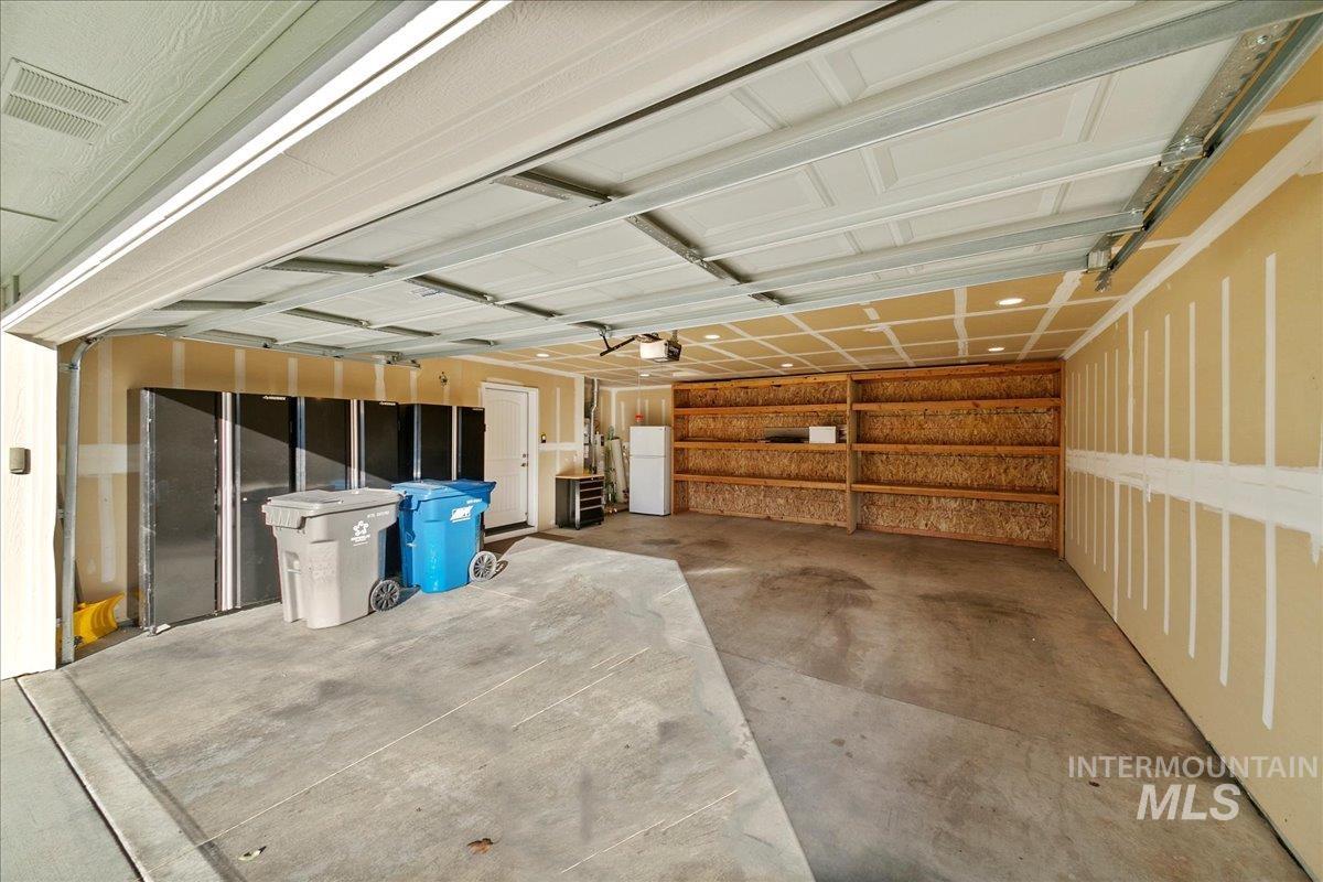 Garage featuring freestanding refrigerator