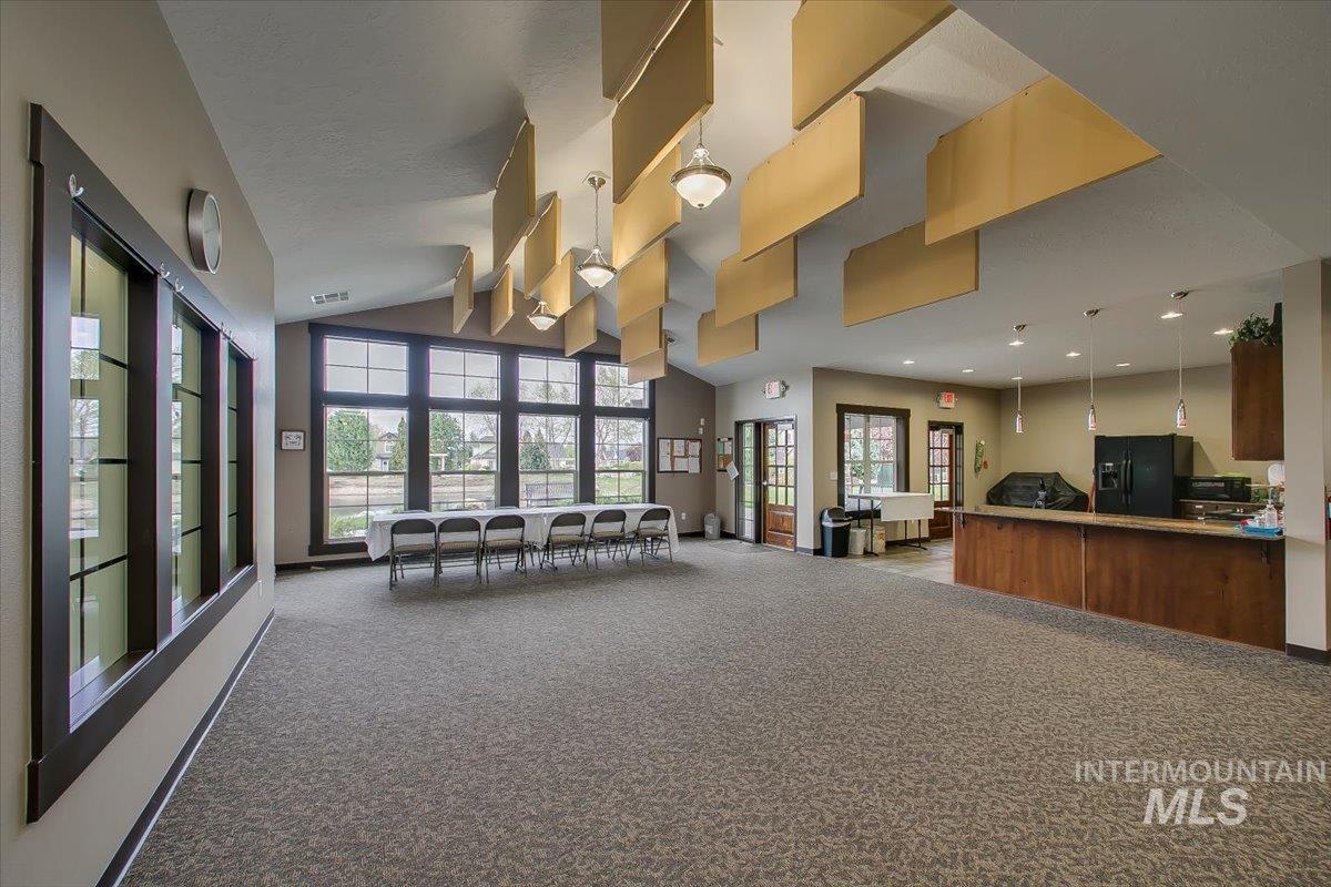 Living area featuring vaulted ceiling and light carpet