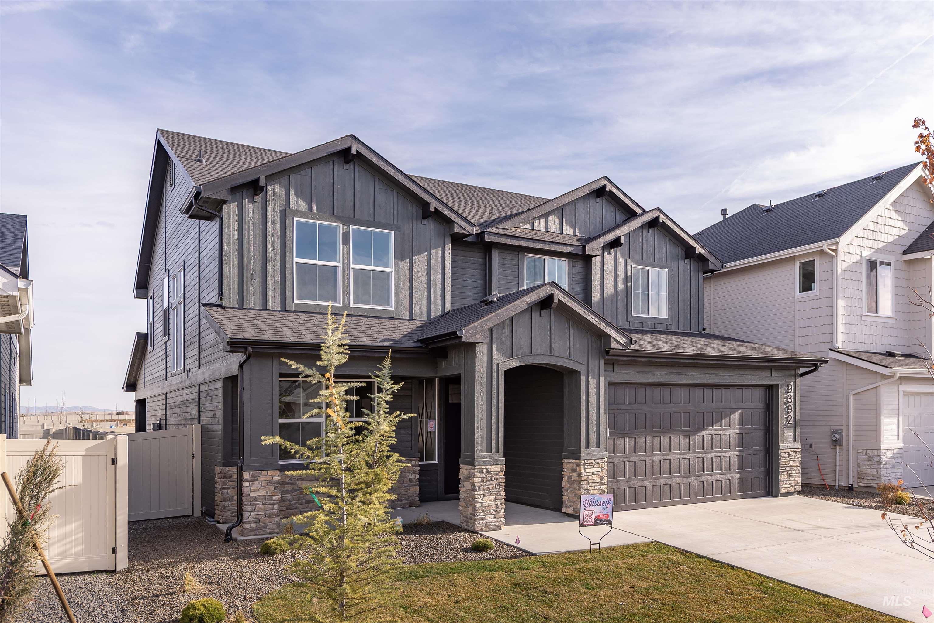 Craftsman-style home with board and batten siding, stone siding, and roof with shingles