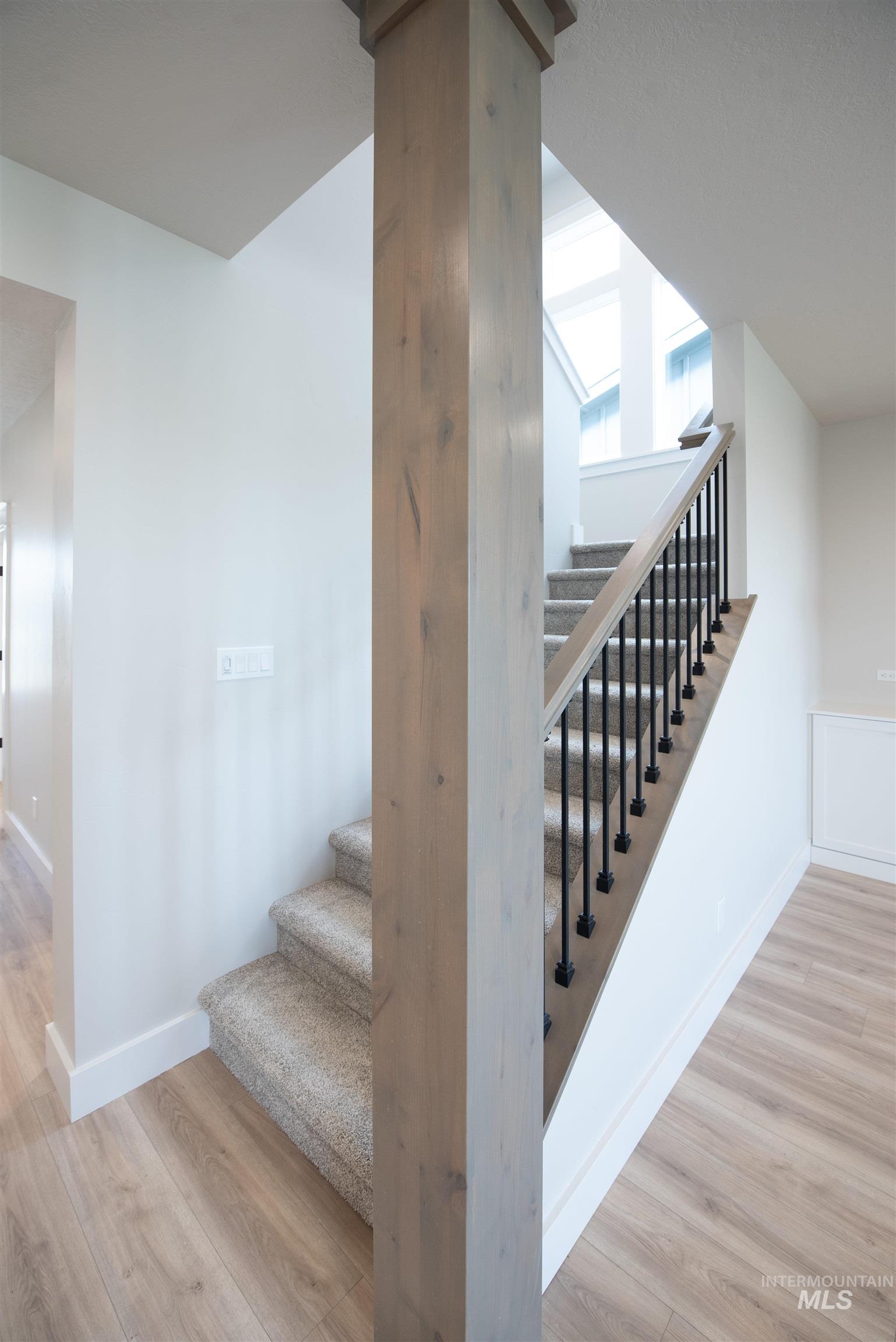 Stairs featuring wood finished floors and baseboards