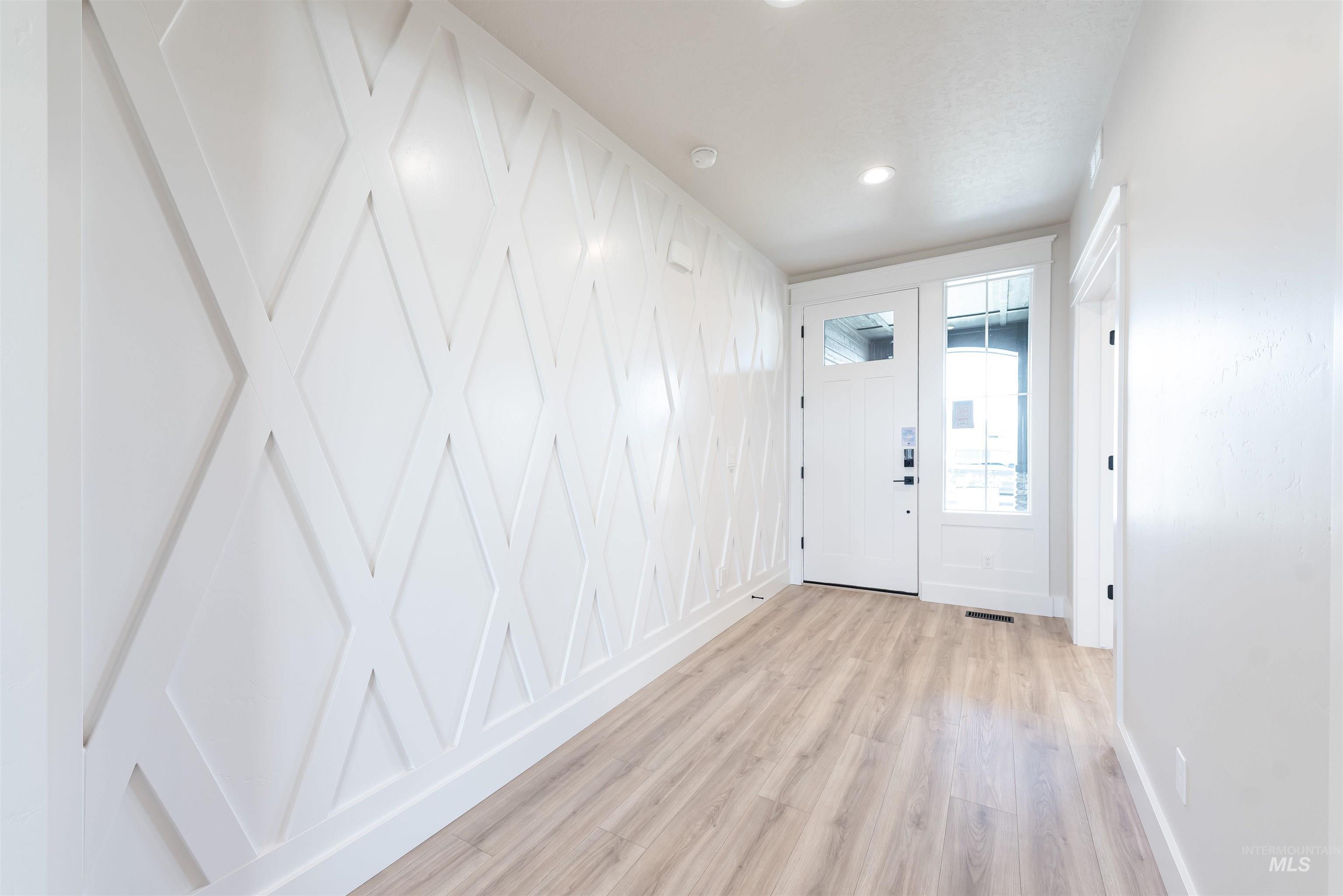 Foyer with light wood-style flooring and recessed lighting