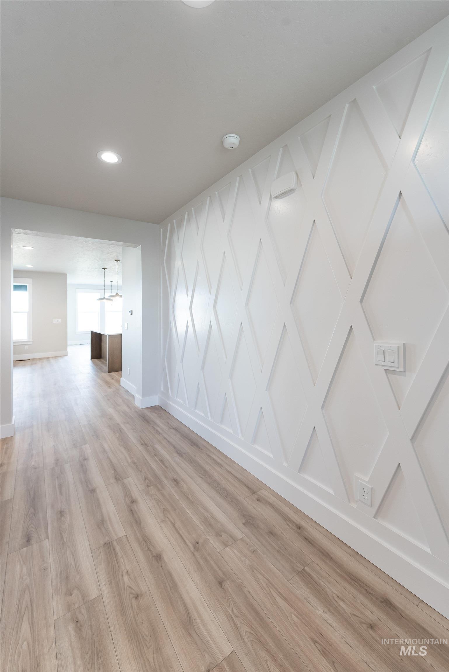 Empty room featuring light wood-style floors and recessed lighting