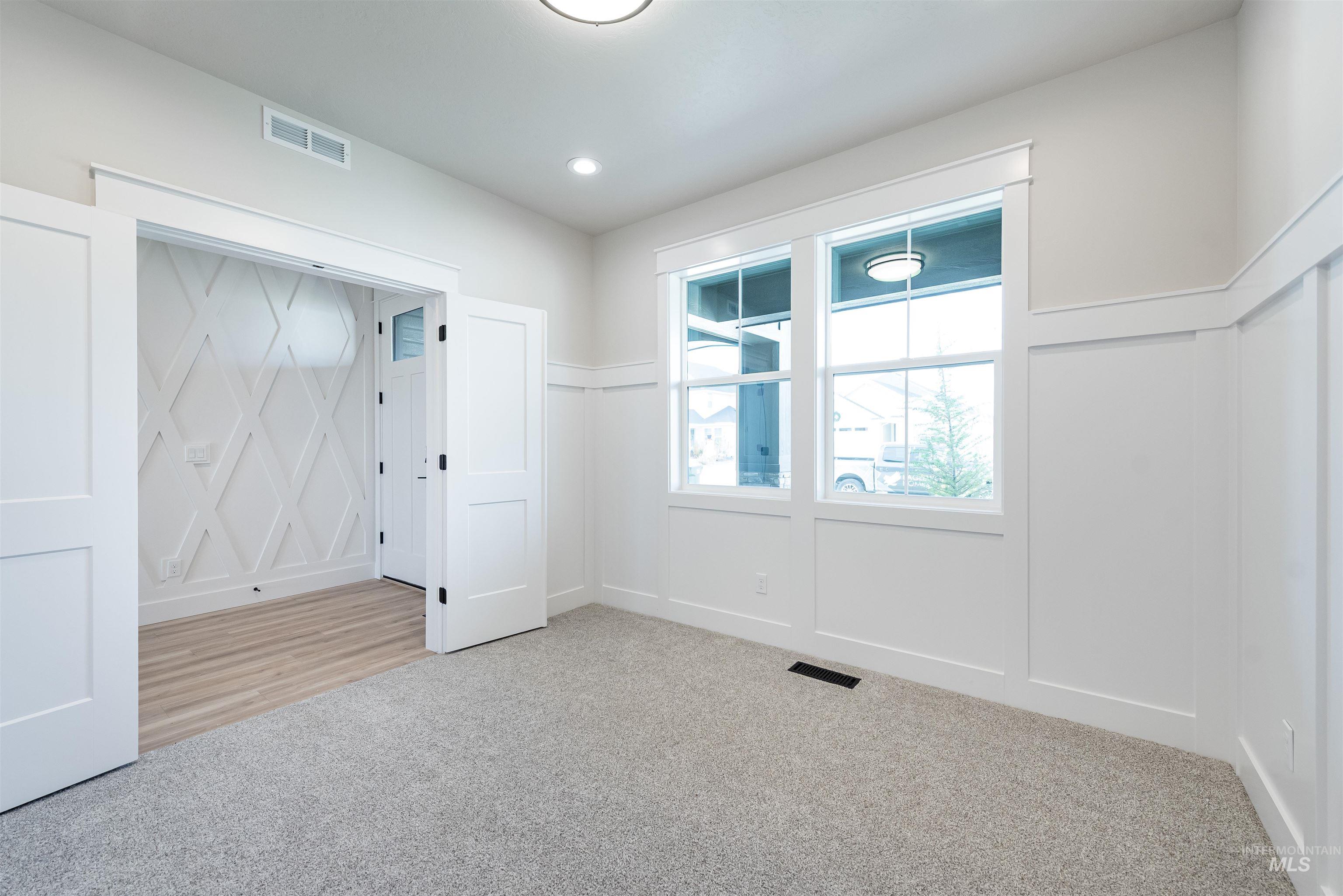 Spare room with a decorative wall, carpet floors, and recessed lighting