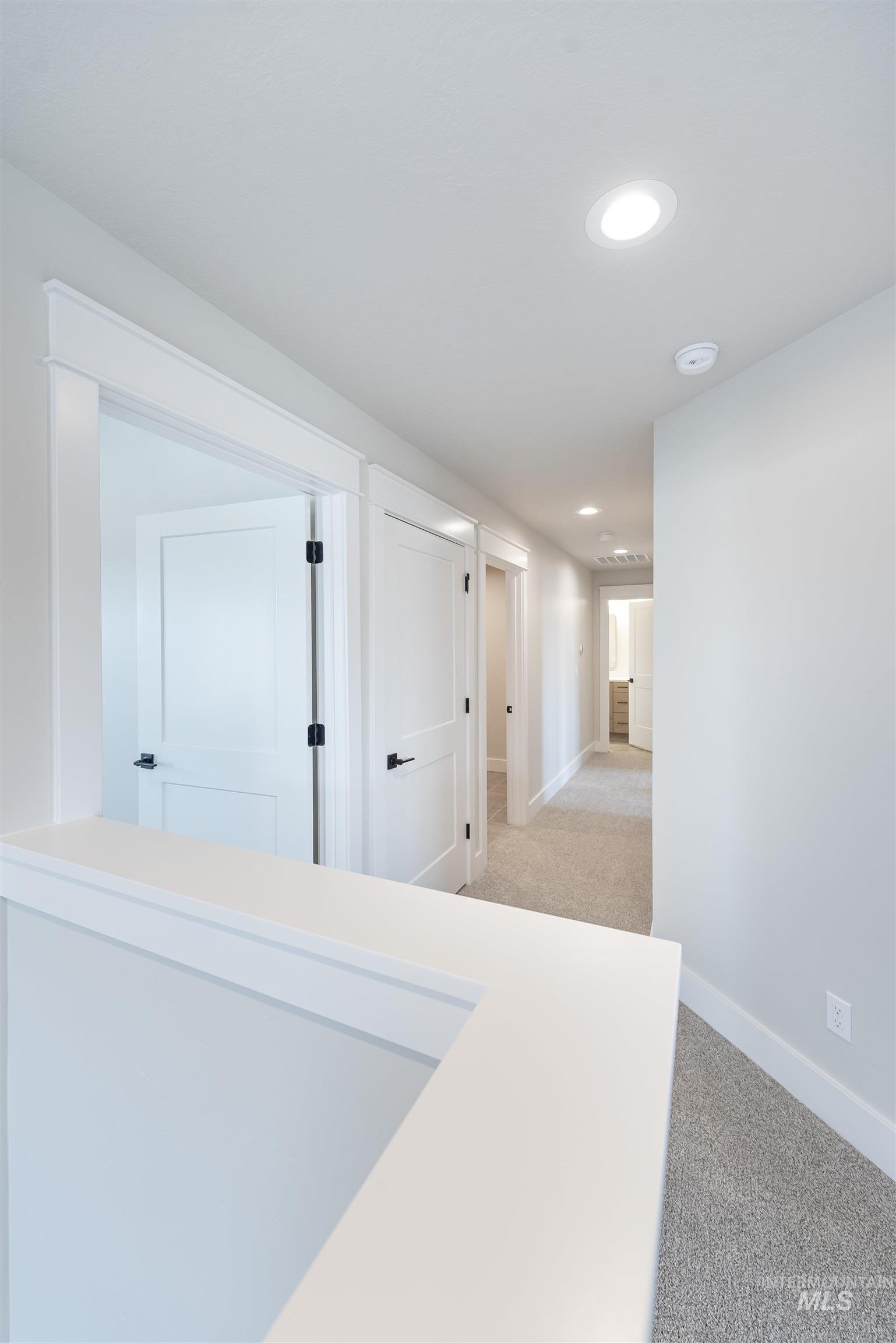 Hall with recessed lighting and light colored carpet