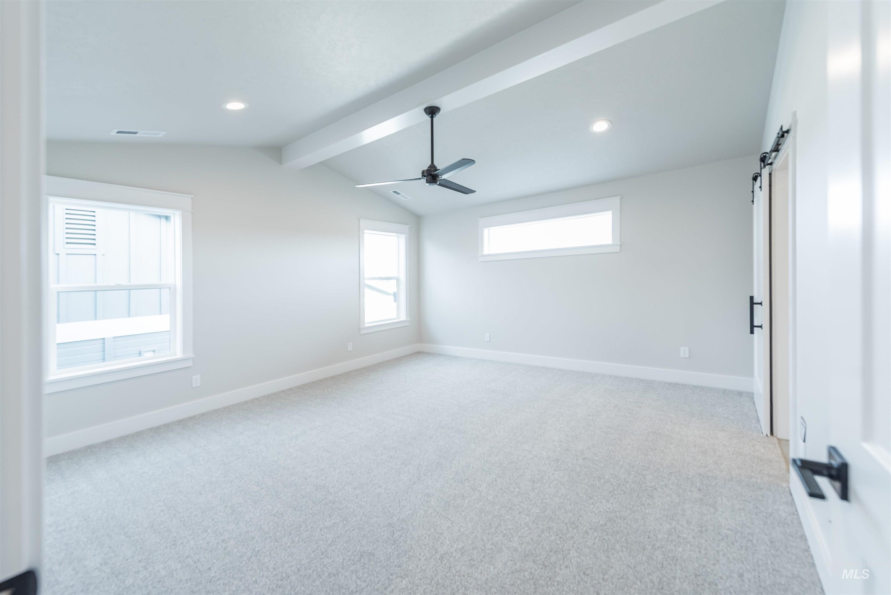 Spare room with a barn door, light colored carpet, a ceiling fan, and recessed lighting