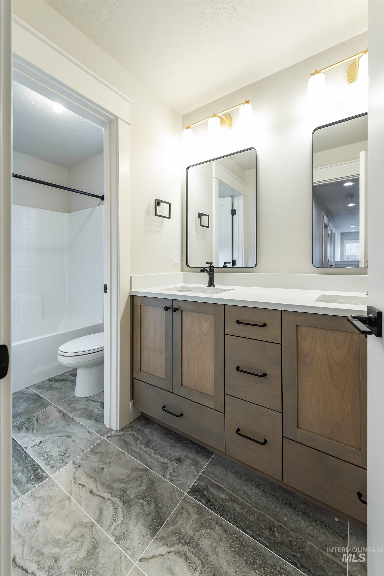 Bathroom featuring double vanity and shower / bath combination