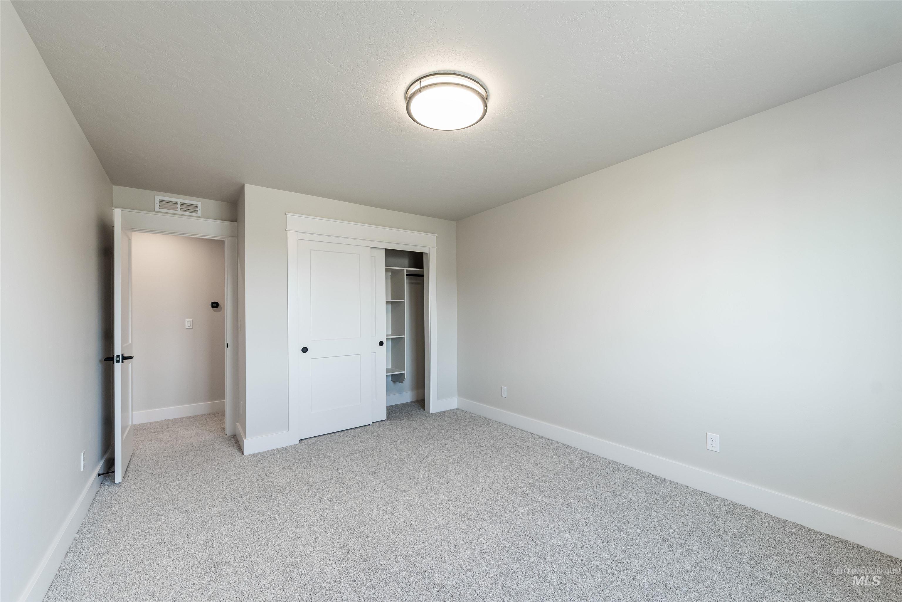 Unfurnished bedroom with a closet and light carpet