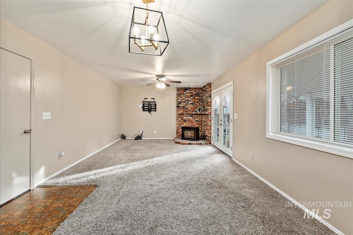 Unfurnished living room with carpet flooring, a fireplace, and ceiling fan