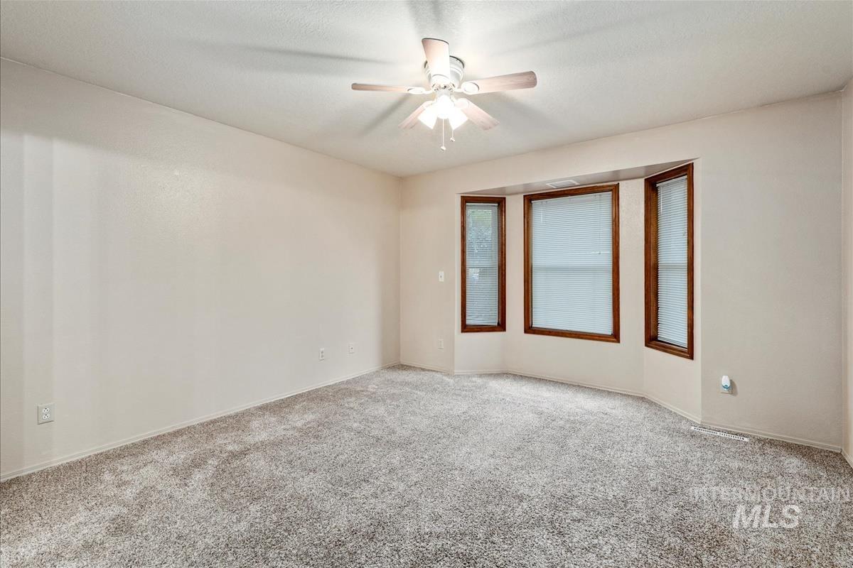 Unfurnished room with carpet flooring and a ceiling fan