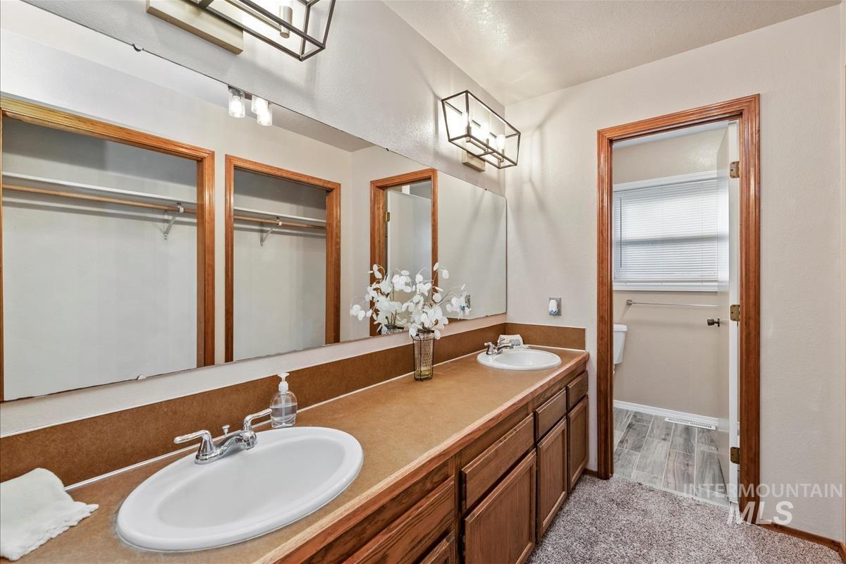 Bathroom with double vanity and baseboards