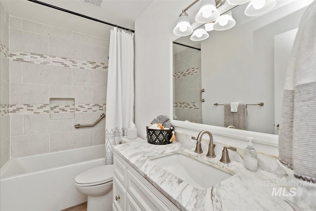 Full bath with vanity, shower / tub combo, and a chandelier