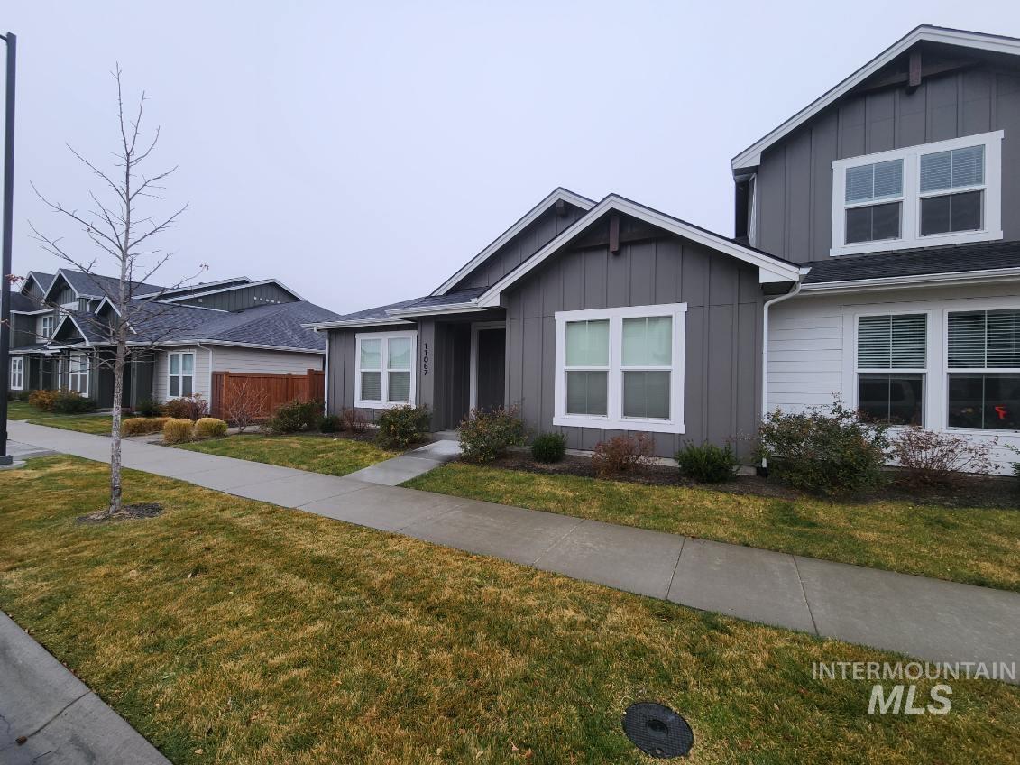 View of front of property with board and batten siding and a front lawn