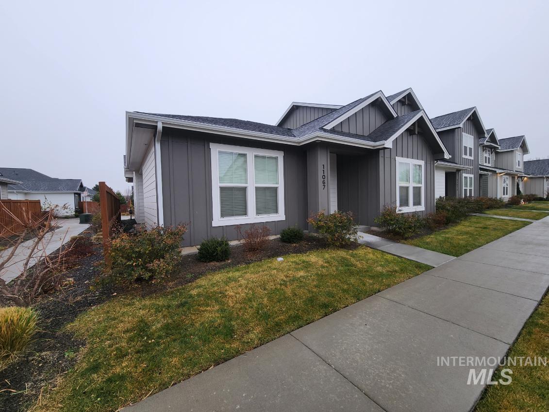 View of front of house with board and batten siding and a front lawn
