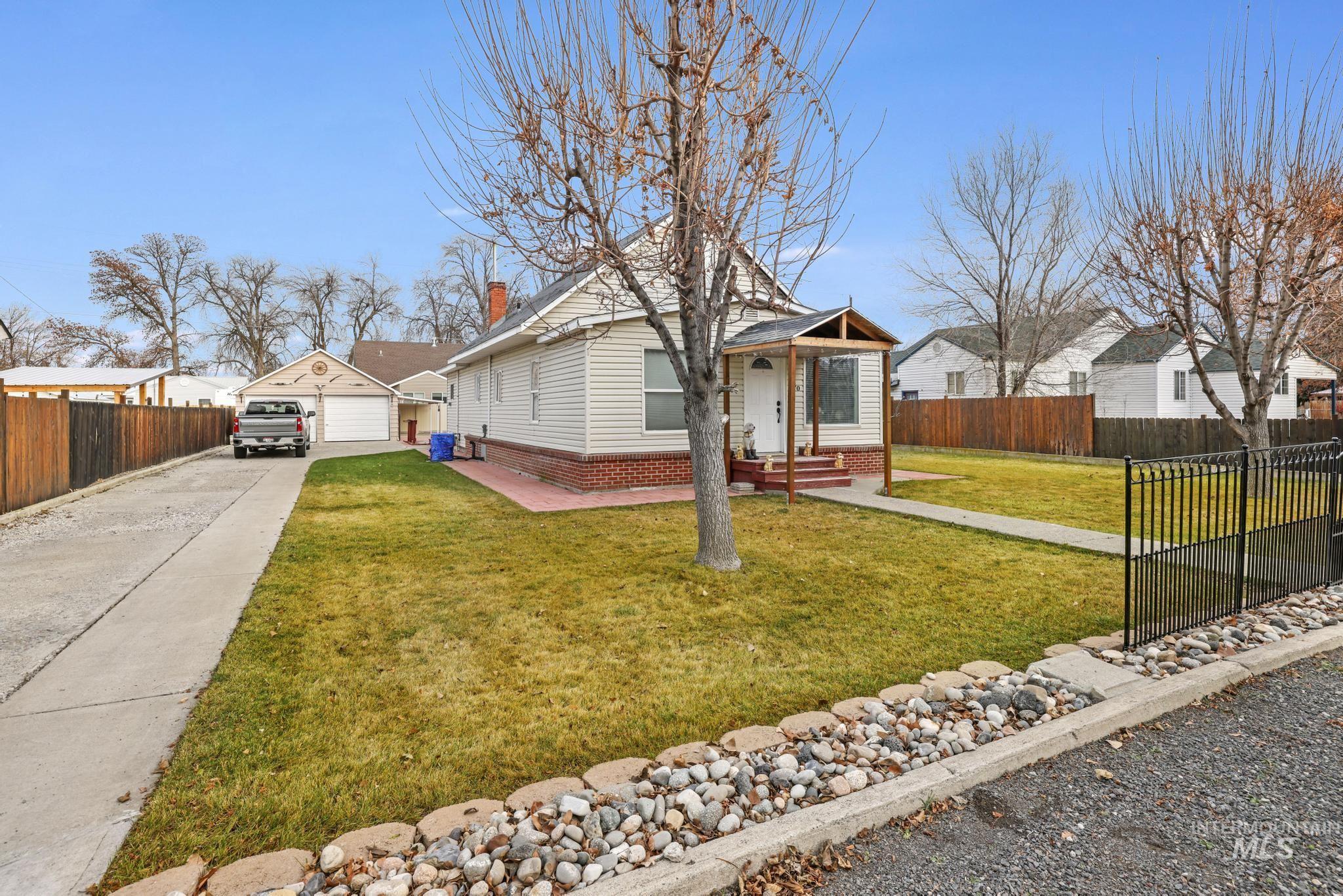 View of front of property with a garage, a chimney, and a porch