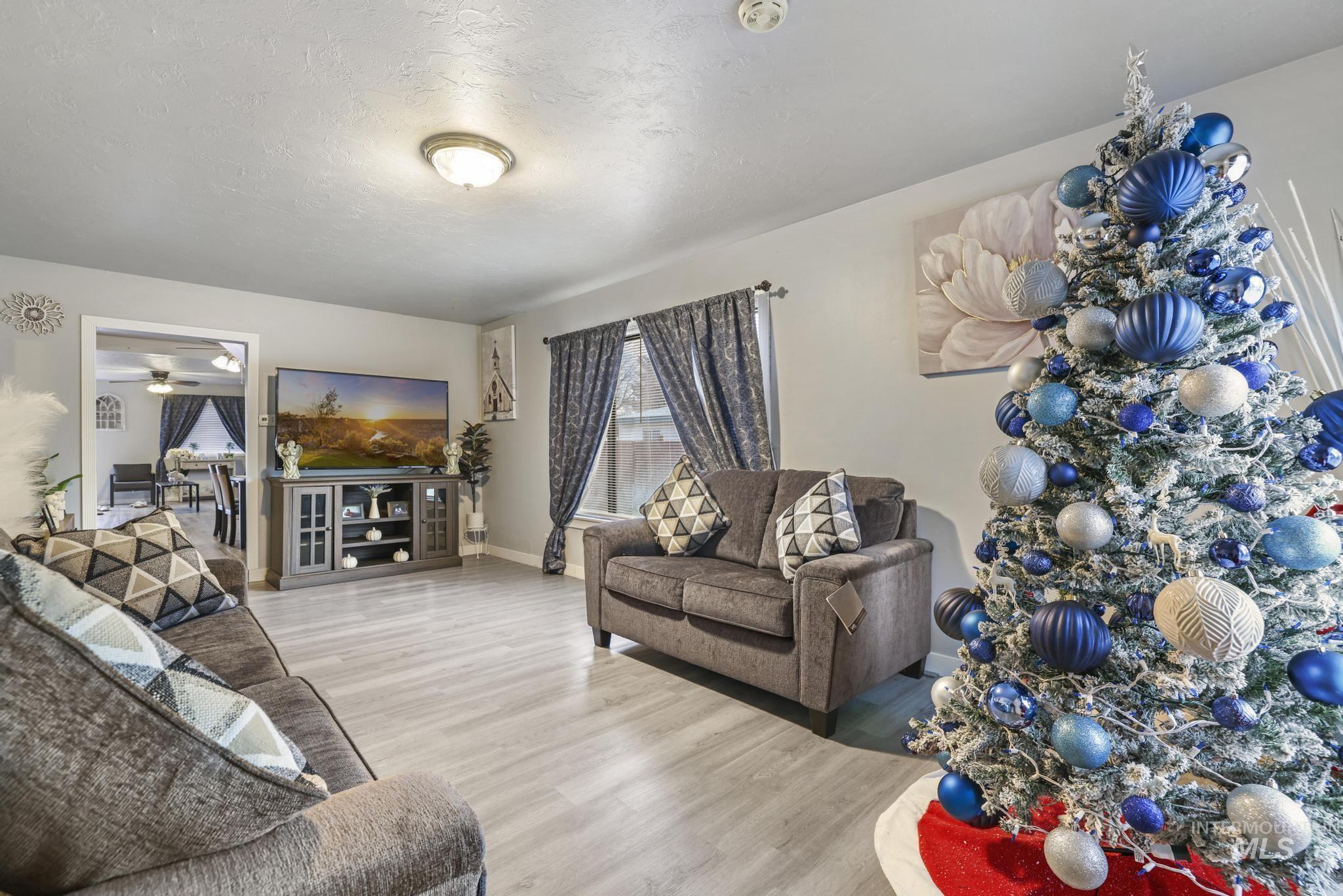 Living room featuring a textured ceiling, wood finished floors, and a ceiling fan