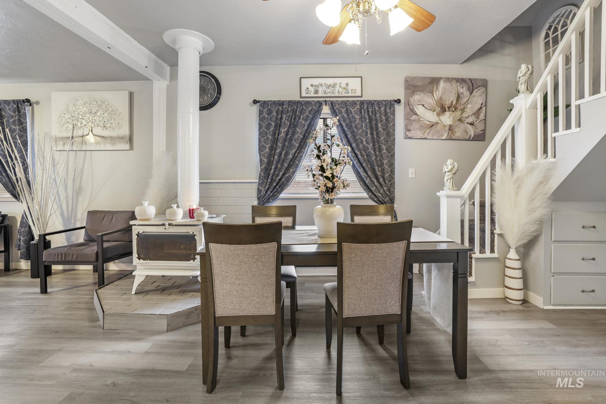 Dining area with stairs, light wood-type flooring, and a ceiling fan