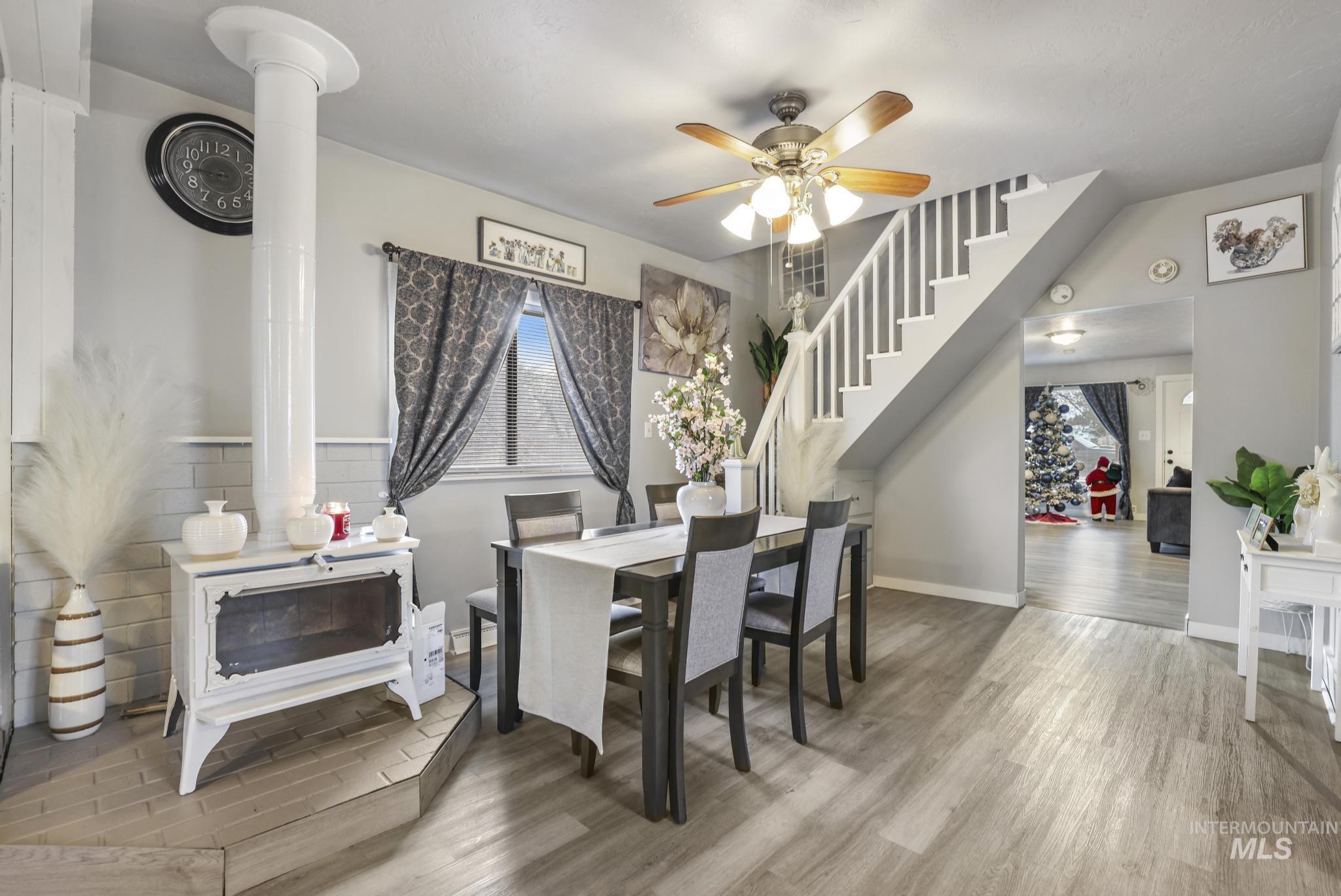Dining room featuring stairs, light wood-type flooring, and a ceiling fan