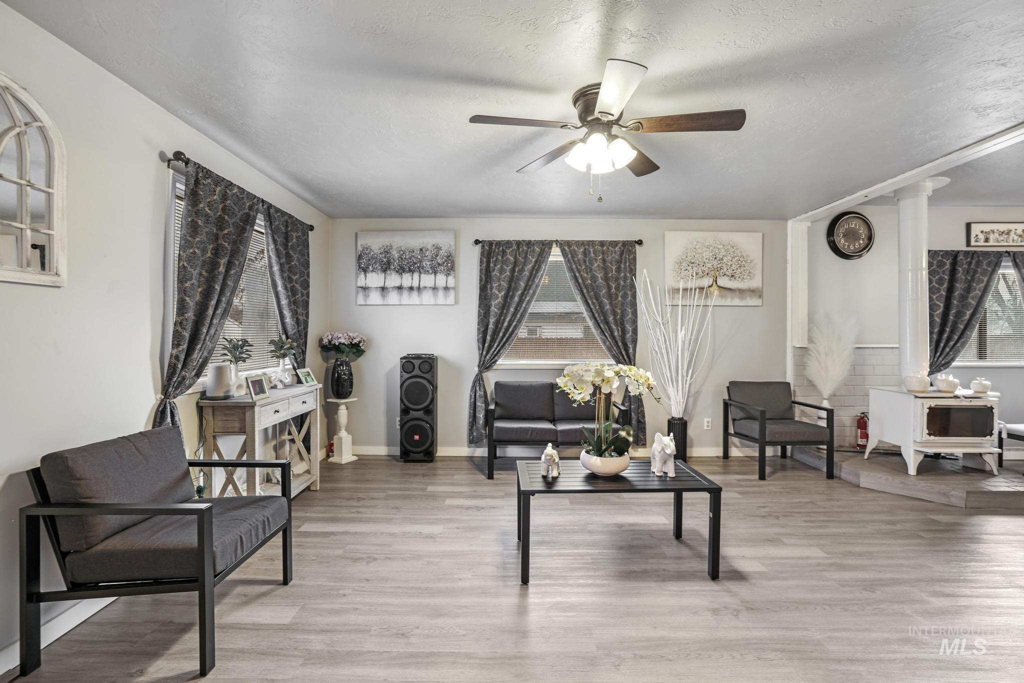 Living area with healthy amount of natural light, light wood finished floors, and a textured ceiling