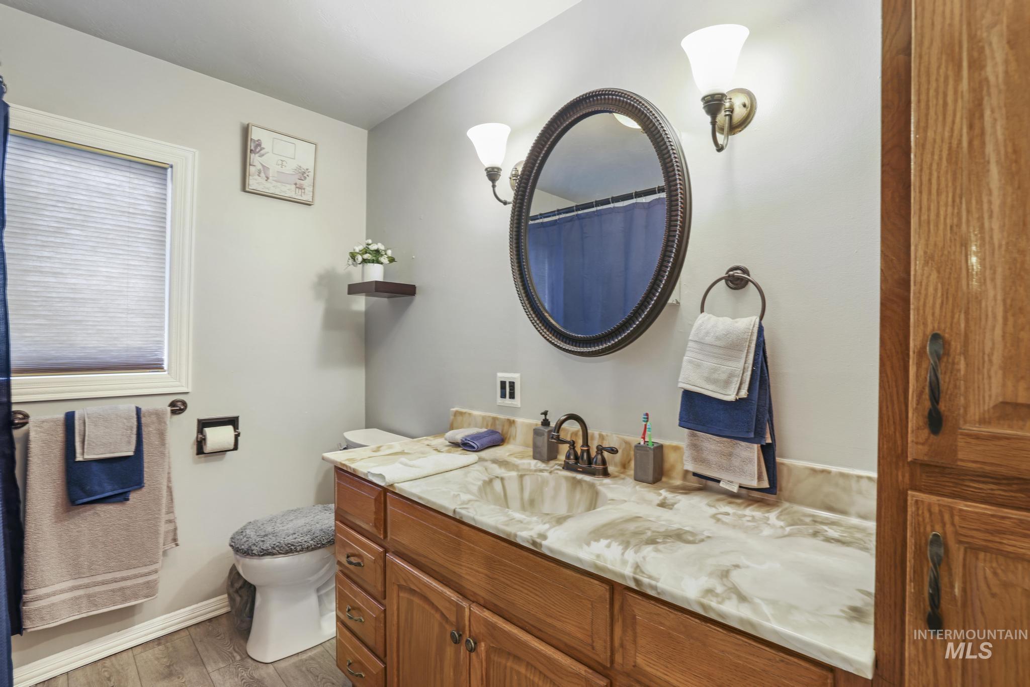 Bathroom with a shower with shower curtain, vanity, and light wood-type flooring