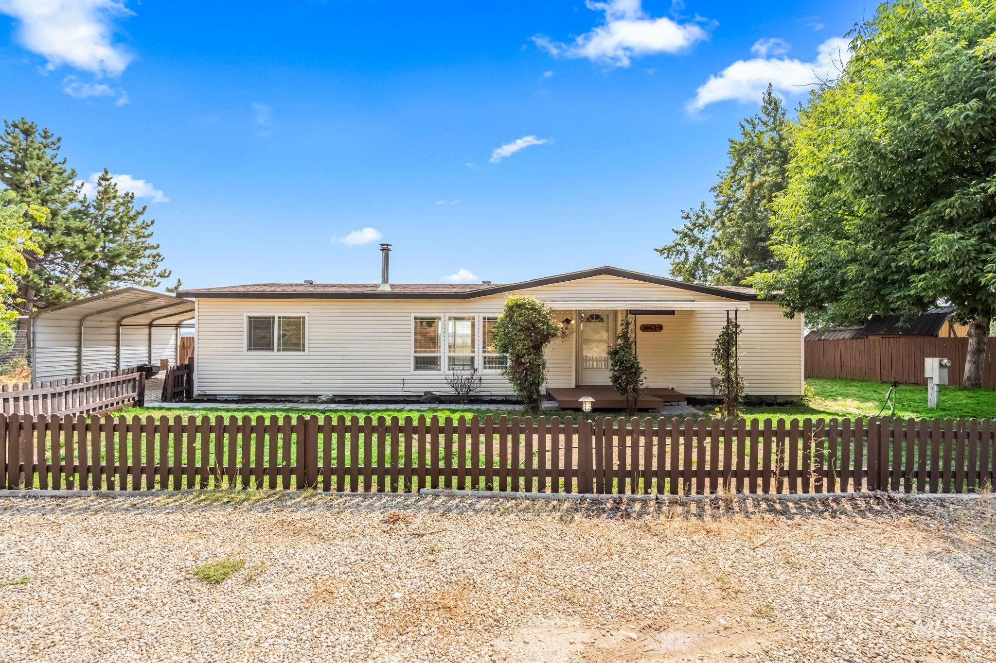 View of front of property with a carport and a fenced front yard