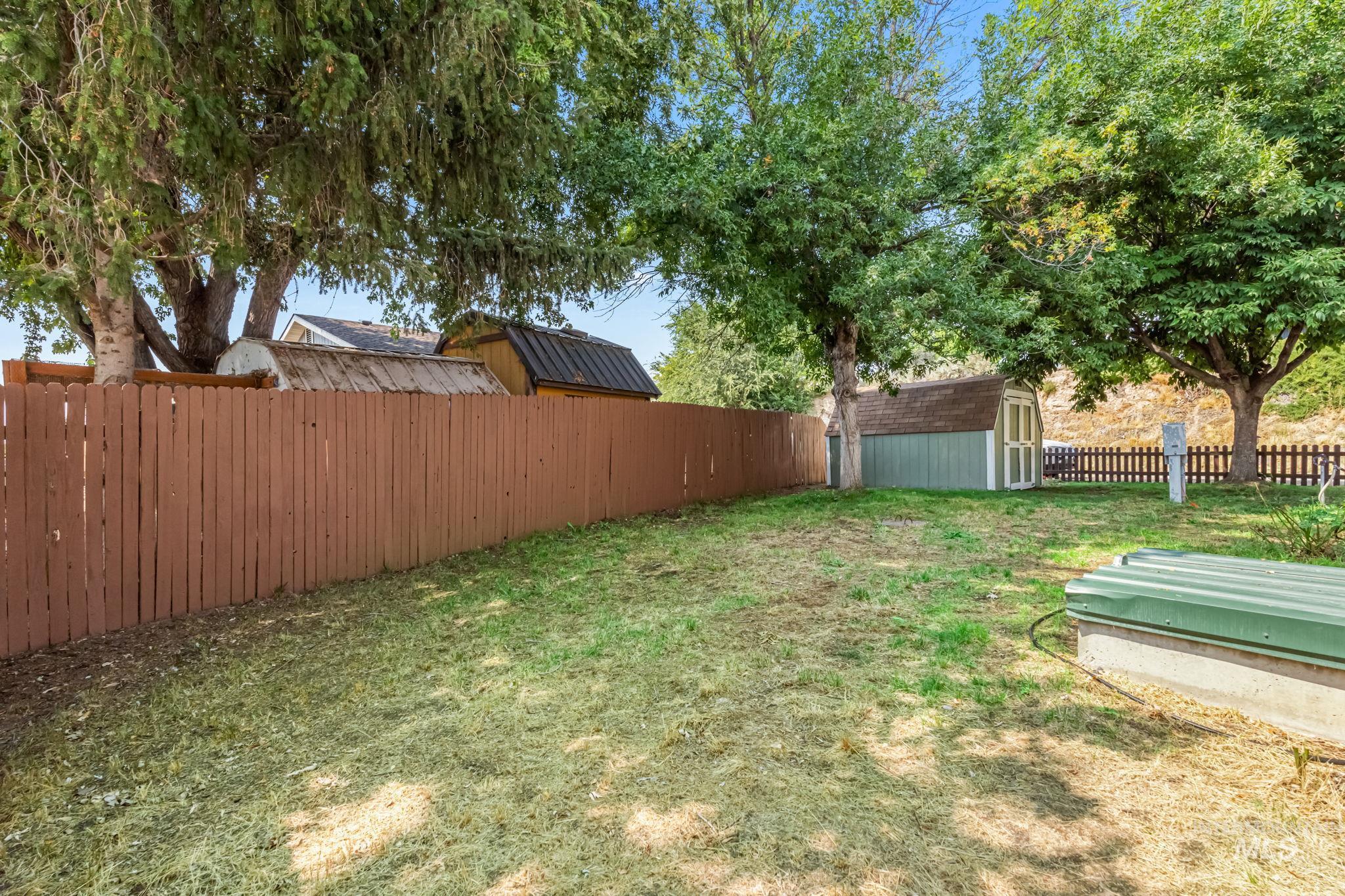 Fenced backyard with a storage shed