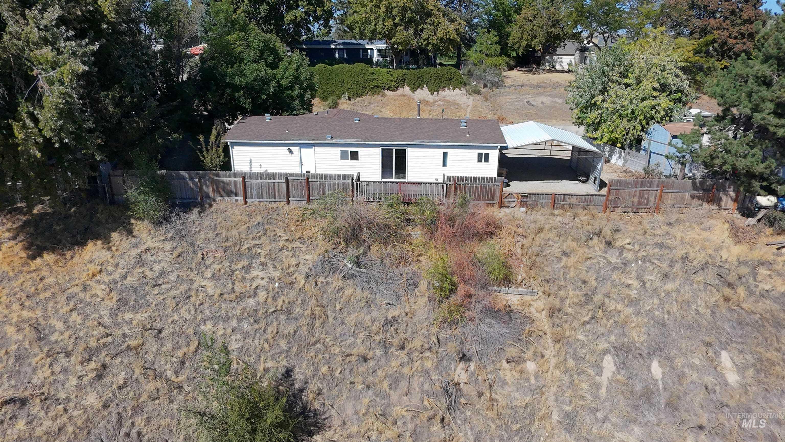 Aerial view of property and surrounding area featuring a tree filled landscape