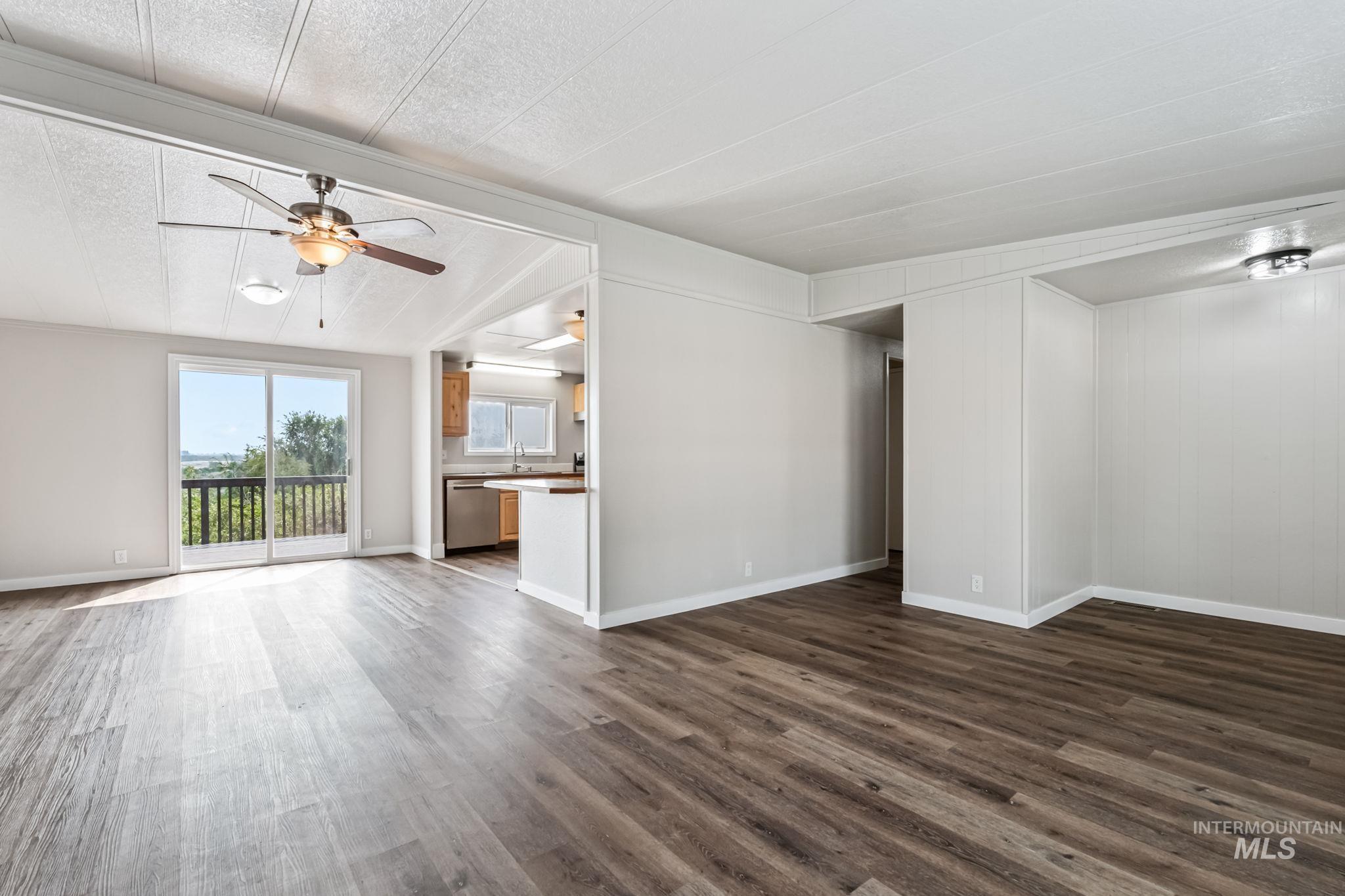 Unfurnished living room with dark wood-style floors, a textured ceiling, and ceiling fan