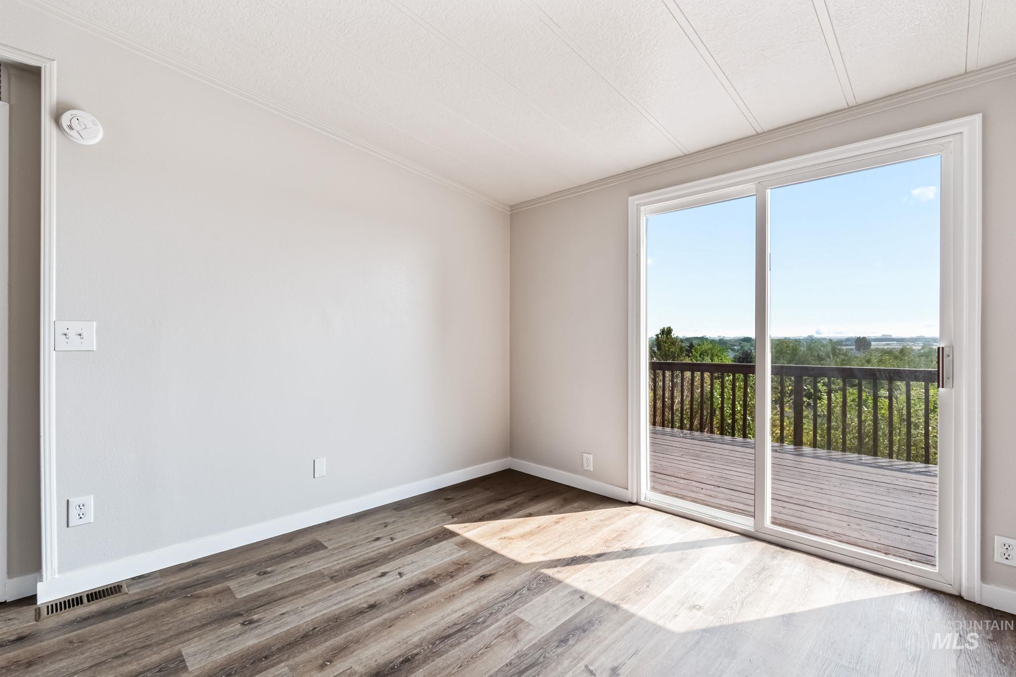 Unfurnished room featuring wood finished floors and ornamental molding