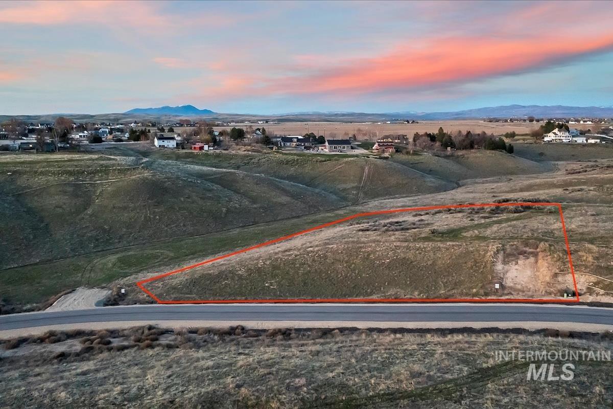 Aerial view at dusk of property parcel outlined and a mountain view