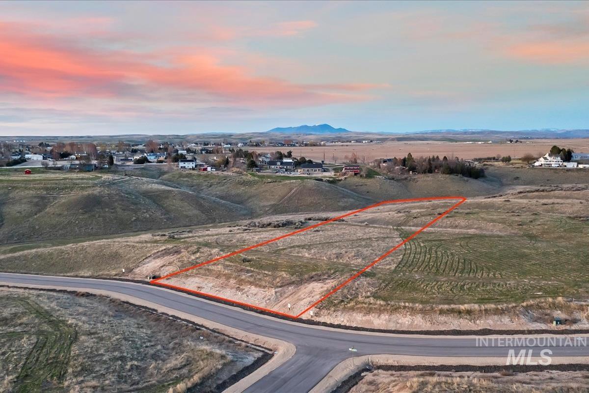 Aerial view at dusk of a view of countryside, property parcel outlined, and a mountain view