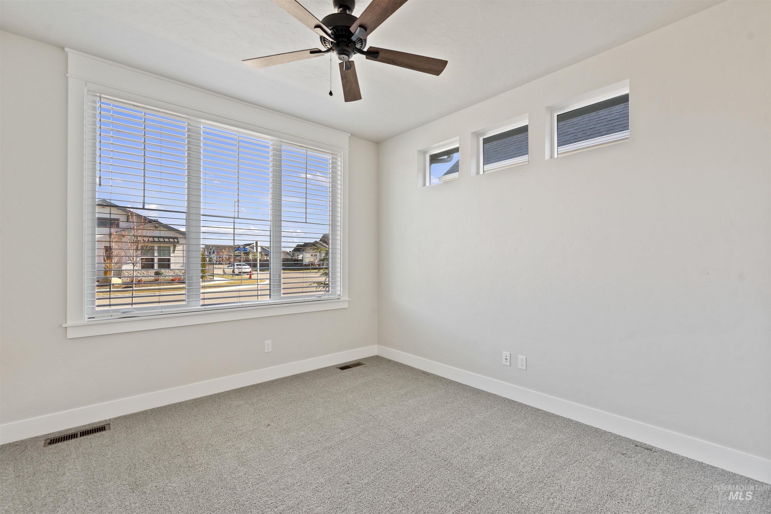 Spare room with light colored carpet and a ceiling fan