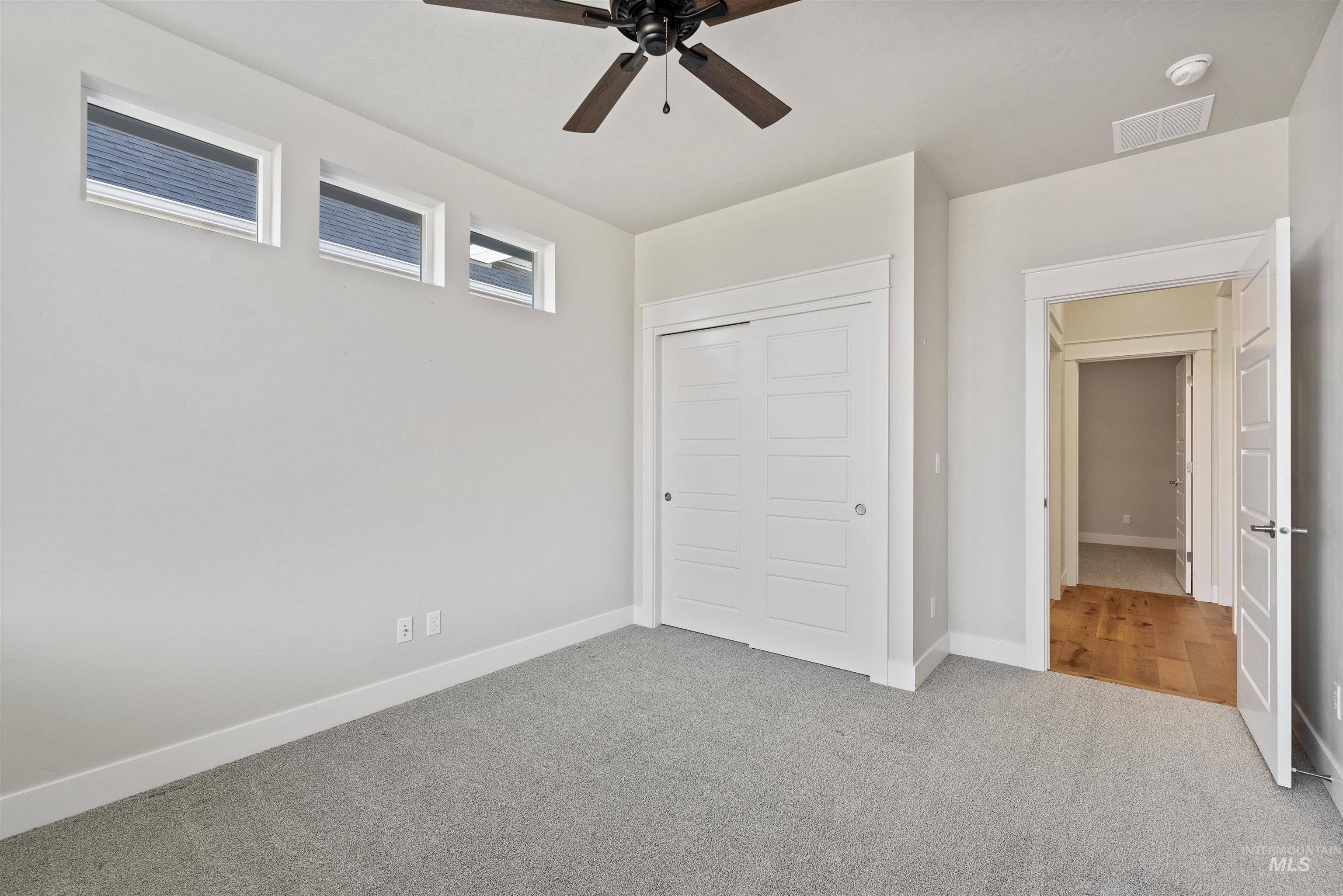 Unfurnished bedroom featuring a closet, carpet, and ceiling fan