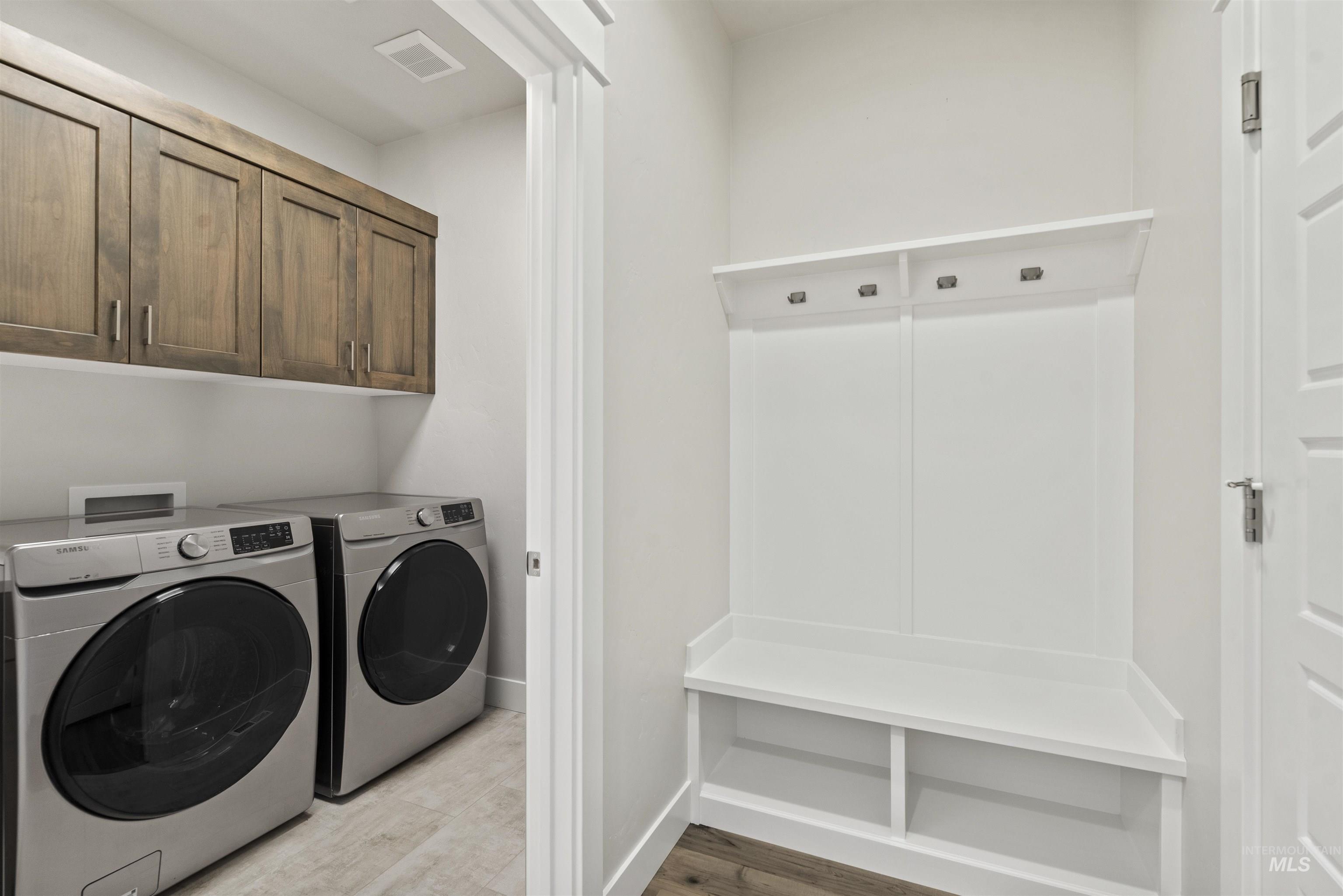 Laundry area with washer and dryer and light wood finished floors