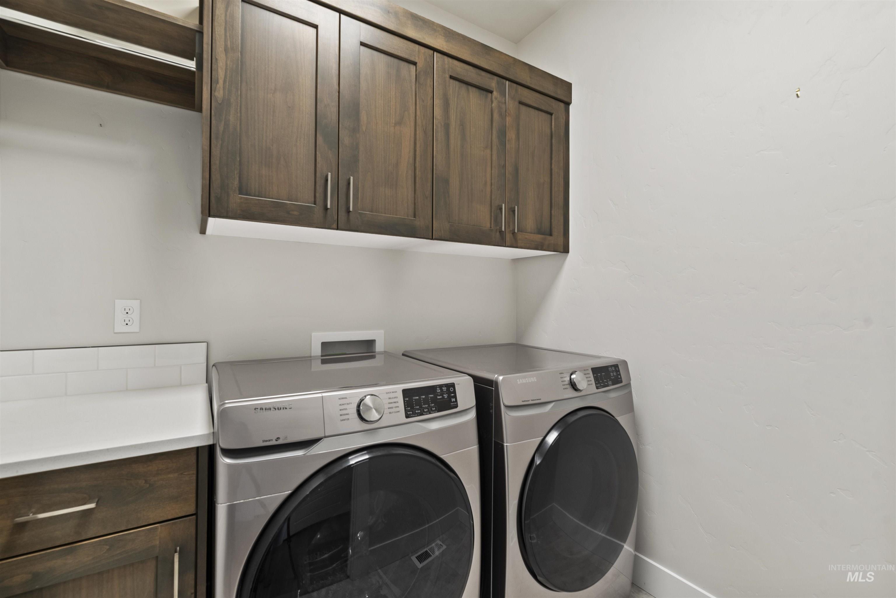 Washroom with cabinet space and washing machine and dryer