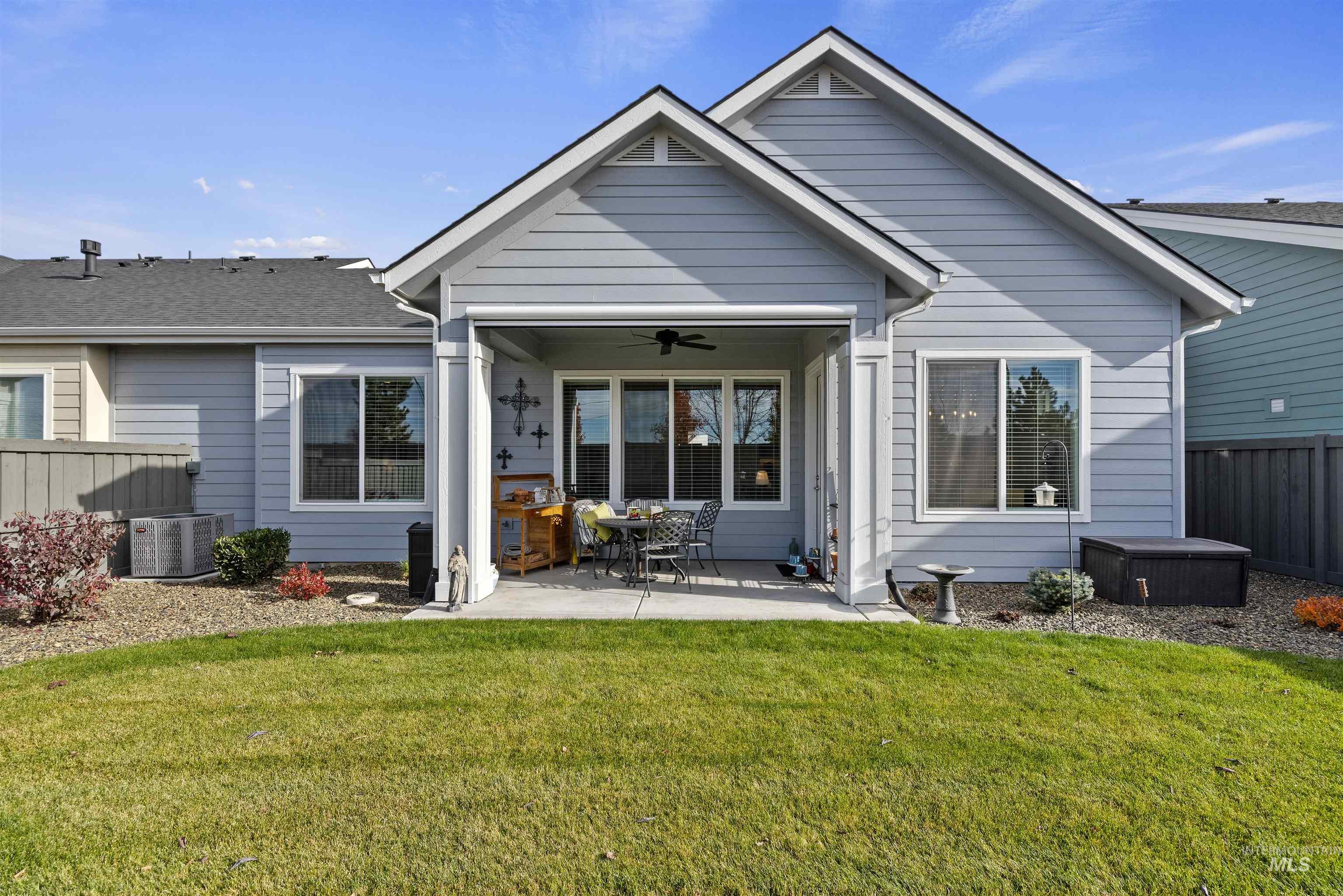 Back of property with a ceiling fan and a patio