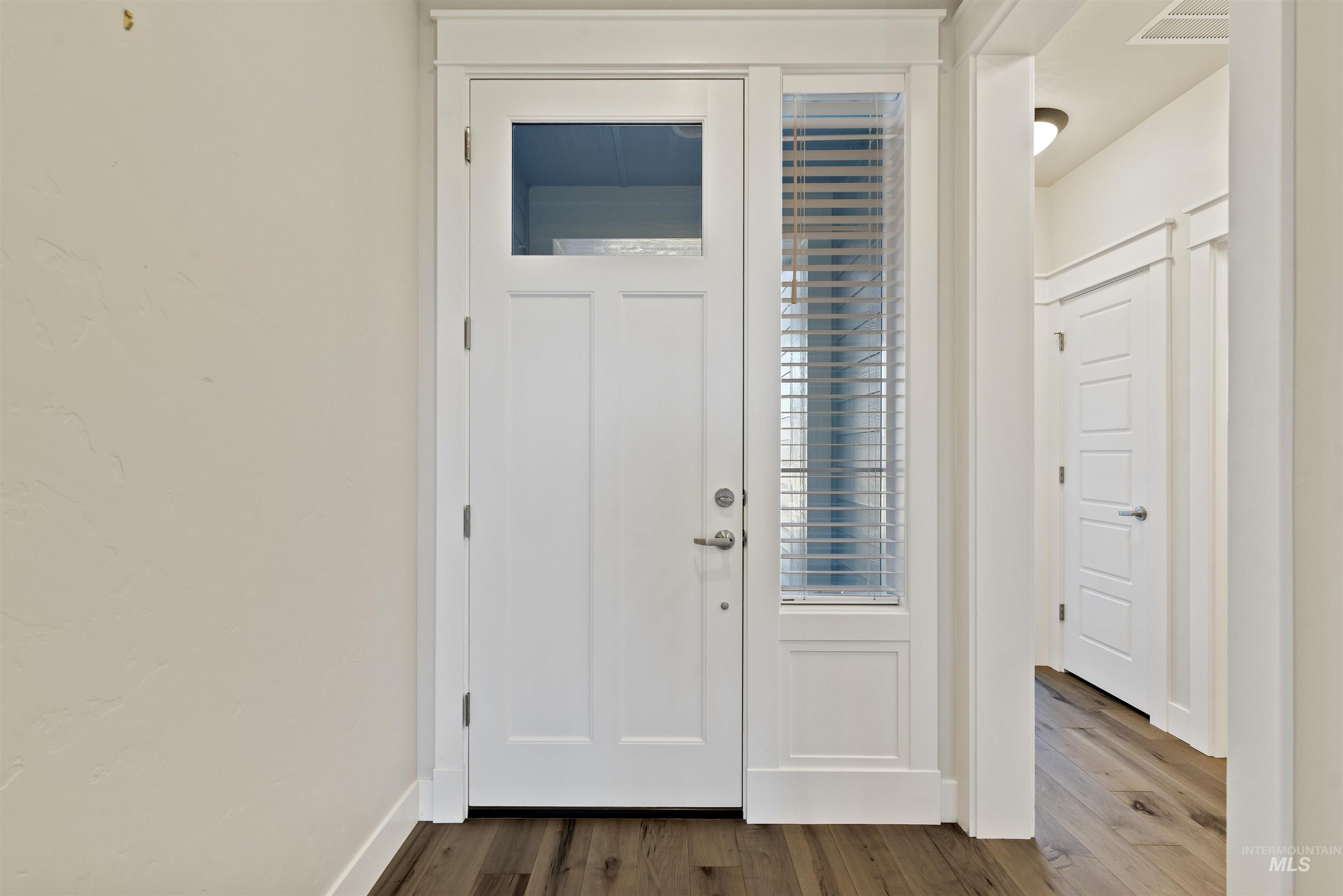 Foyer featuring dark wood finished floors and baseboards