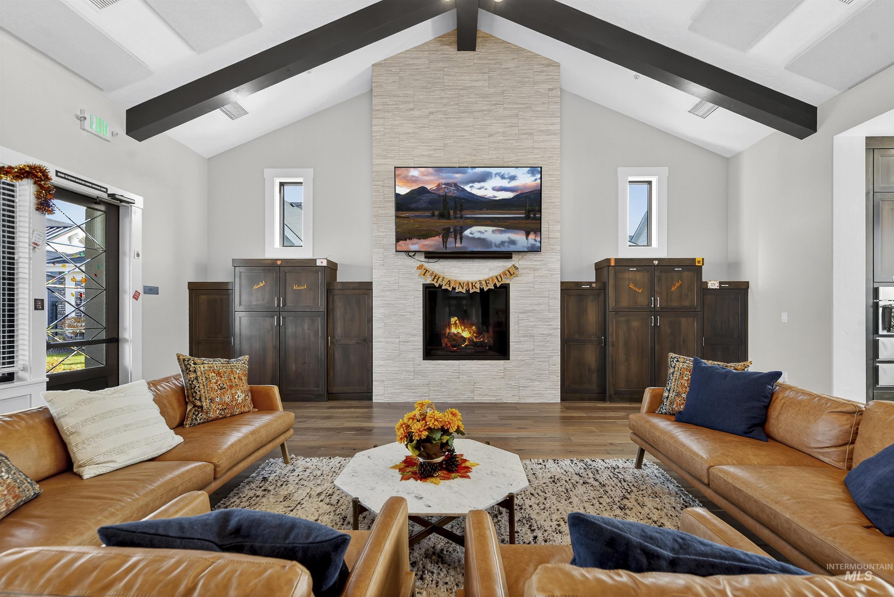 Living area with a large fireplace and wood finished floors