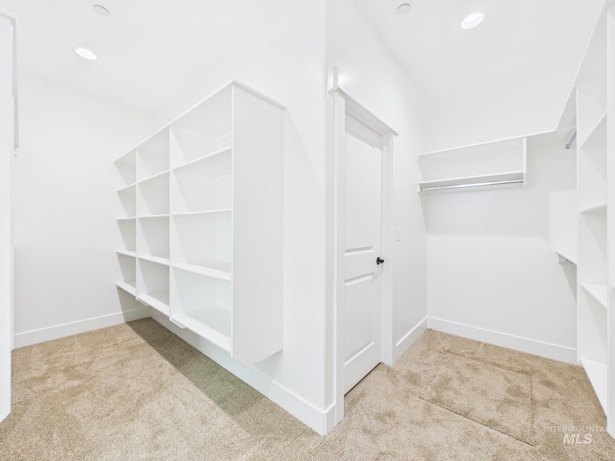 Spacious closet with light colored carpet