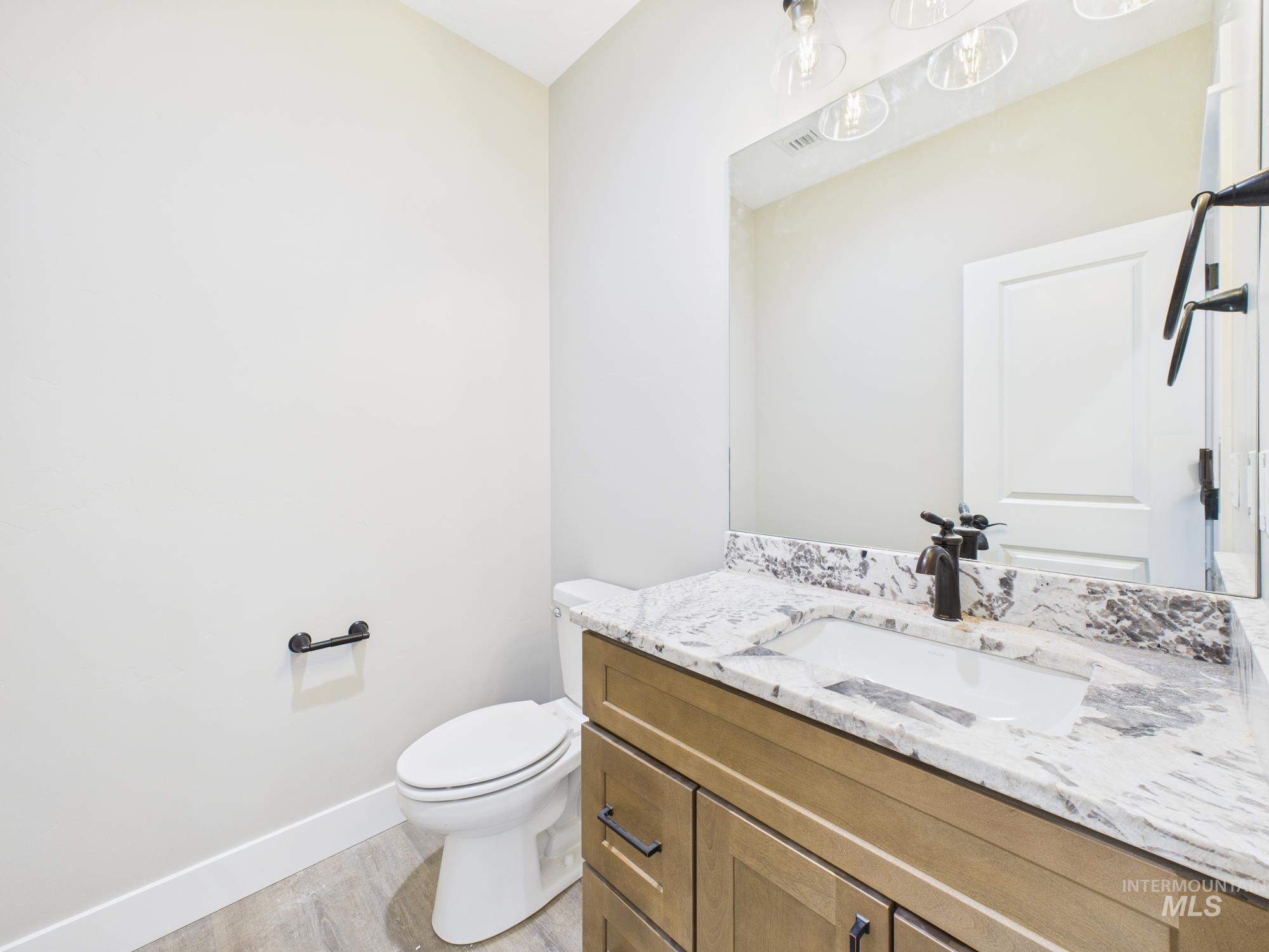 Half bathroom featuring vanity and light wood finished floors